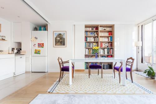 une cuisine et une salle à manger avec une table et des chaises dans l'établissement Beautiful Paris Centre apartment in garden, à Paris