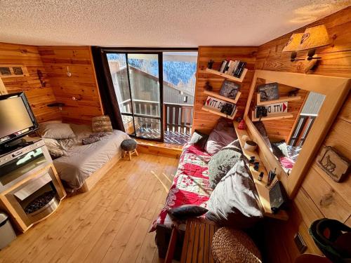 - une chambre dans une cabane en rondins avec un lit et une fenêtre dans l'établissement Charmant studio avec vue dégagée, à Isola