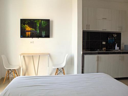 Un dormitorio con una cama y una mesa y sillas. en 402 studio apartment in El Peñon, en Cali