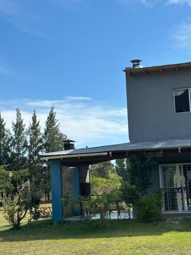 a house with a blue pillar and a building at Casaquinta Sunrise La Plata in Abasto