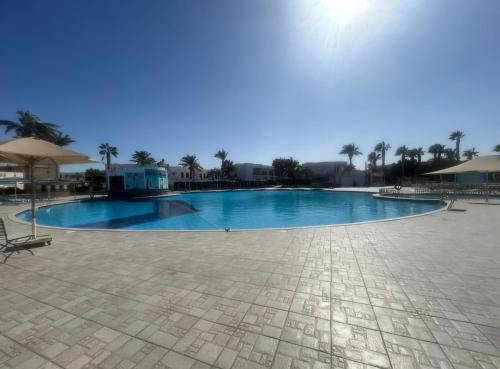 a large swimming pool in the middle of a courtyard at Hurghada Mirage Bay Hotel & Aquapark in Hurghada