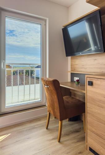 a room with a desk and a large window at Hotel Restaurant Traube Kallstadt in Kallstadt