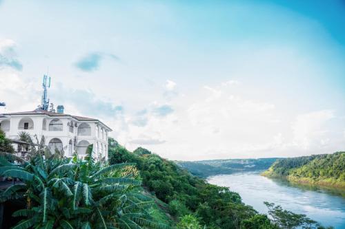 a building on a hill next to a river at Hotel Casablanca Boutique Ciudad del Este By Swiss Bonmont Hotels in Ciudad del Este