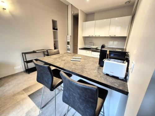 - une cuisine avec un comptoir avec des chaises et un comptoir dans l'établissement Résidence Le Bernascon - Cosy studio proche d'un agréable Parc 