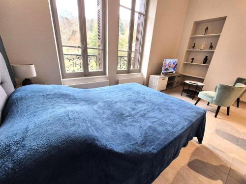 une chambre avec un lit bleu et une fenêtre dans l'établissement Résidence Le Bernascon - Cosy studio proche d'un agréable Parc 