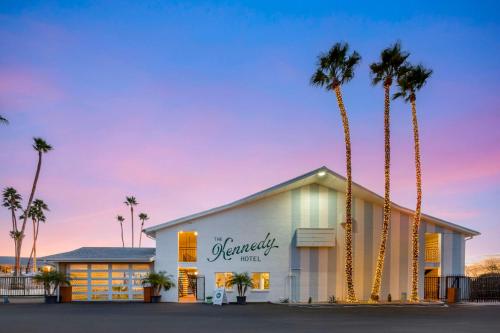 a building with palm trees in front of it at The Kennedy Tucson, SureStay Collection by Best Western in Tucson