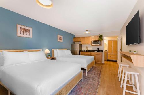 a hotel room with two beds and a kitchen at The Kennedy Tucson, SureStay Collection by Best Western in Tucson