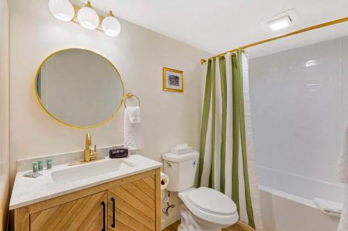 a bathroom with a sink and a toilet and a mirror at The Kennedy Tucson, SureStay Collection by Best Western in Tucson