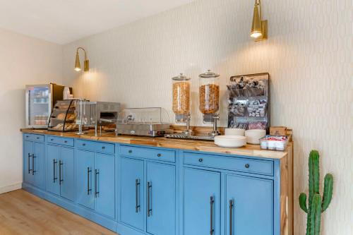 a kitchen with blue cabinets and a cactus at The Kennedy Tucson, SureStay Collection by Best Western in Tucson