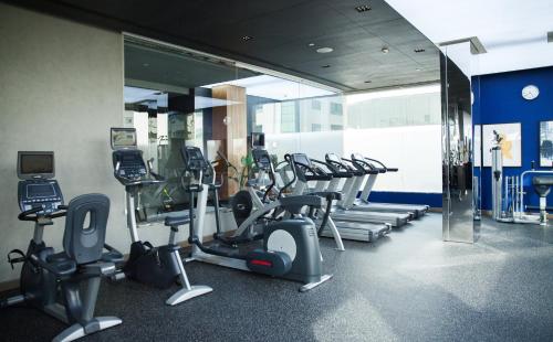 a gym with a bunch of treadmills and mirrors at voco Dubai by IHG in Dubai