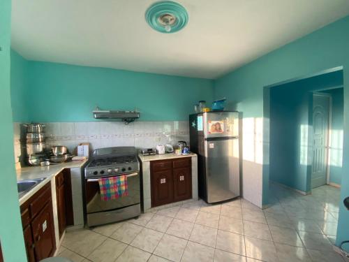 a kitchen with a stove and a refrigerator at Casa Azul - Apartment in San Felipe de Puerto Plata
