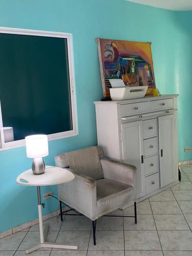 a chair and a desk and a chalkboard in a room at Casa Azul - Apartment in San Felipe de Puerto Plata
