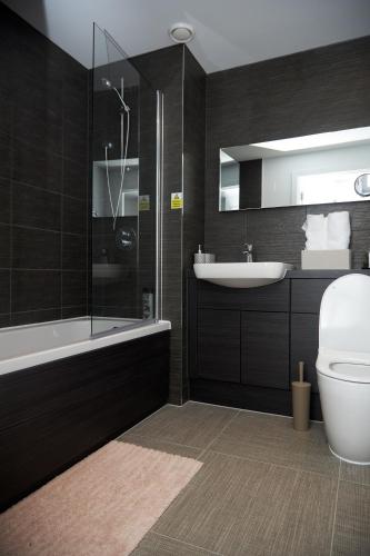 a bathroom with a toilet and a sink and a shower at Luxury 2 Bedroom and bathroom in Central Manchester With Balcony in Manchester