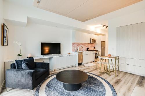 a living room with a black couch and a table at View of Hollywood Sign Studio, Free Parking in Los Angeles