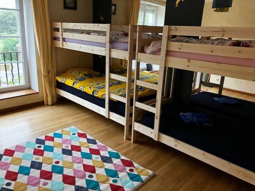 une chambre avec deux lits superposés et un tapis dans l'établissement Au pied du Lac, à Gérardmer