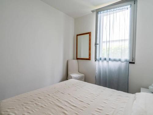 Un dormitorio blanco con una cama y una ventana. en Crêuza de mä - tranquillità e natura ad Alassio, en Alassio