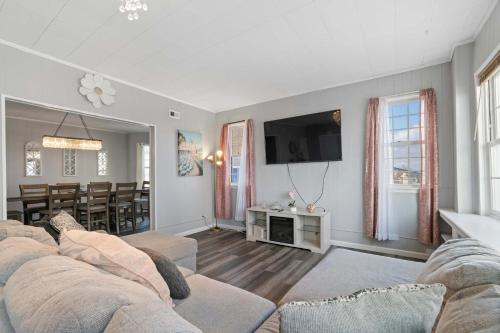 a living room with a couch and a tv at Escape to Raleigh Ave Glamour - Steps to the Beach in Atlantic City