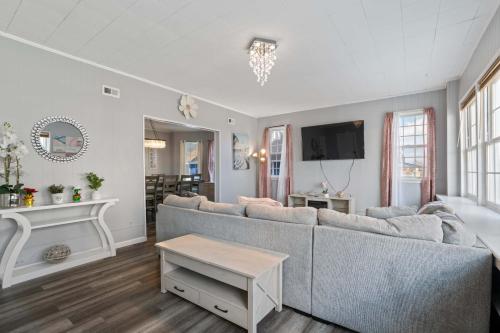 a living room with a couch and a tv at Escape to Raleigh Ave Glamour - Steps to the Beach in Atlantic City