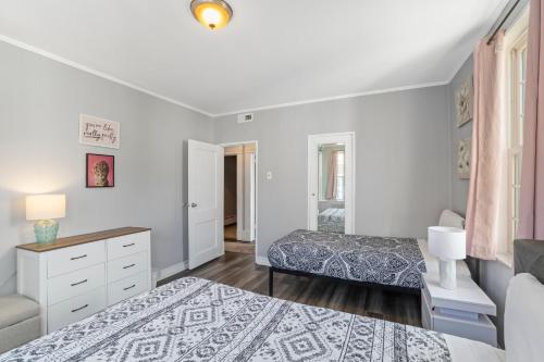 a bedroom with two beds and a dresser at Escape to Raleigh Ave Glamour - Steps to the Beach in Atlantic City