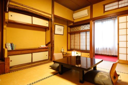 a living room with a table and a window at 城崎温泉 旅館 つばき乃 - Kinosaki Onsen Ryokan Tsubakino in Toyooka