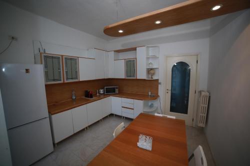 a kitchen with white cabinets and a wooden table at CozyNeat Hub in Turin