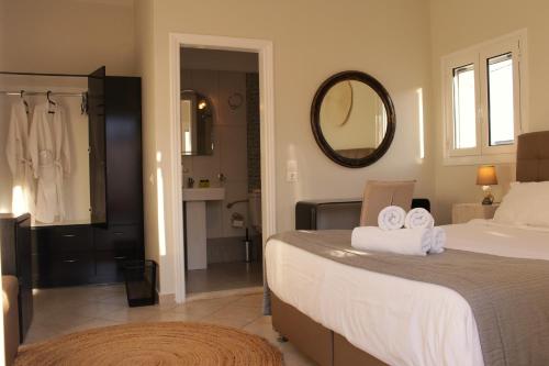 a bedroom with a bed and a bathroom with a mirror at Villa Libertad in Imerovigli