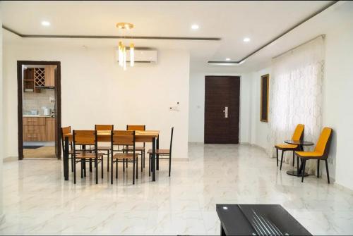 a dining room with a wooden table and chairs at HS Apartment and Duplex in Ogbojo