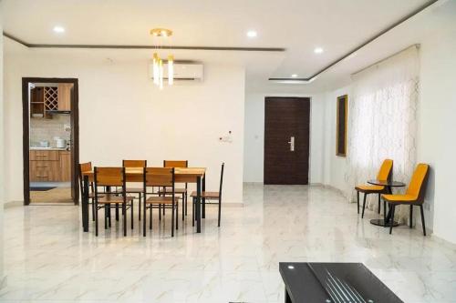 a dining room with a wooden table and chairs at HS Apartment and Duplex in Ogbojo