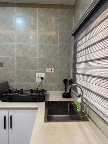 EgganにあるCOZY 2 BEDROOM APARTMENTS FOR SHORT STAY iのシンクとコンロのあるキッチン