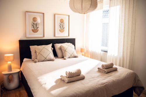 a bedroom with a large bed with towels on it at F I E R Huisje in Eersel