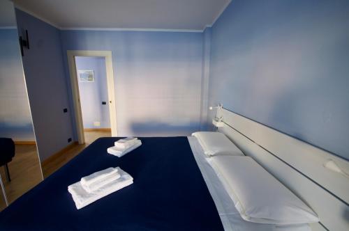 a blue room with a bed with towels on it at H2ome - Il Cembalo vista baia e città balcone o terrazzo parcheggio su richiesta in Genova