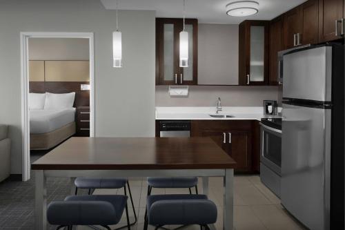 a kitchen with a table and chairs and a bed at Residence Inn by Marriott Fort Lauderdale Airport & Cruise Port in Dania Beach
