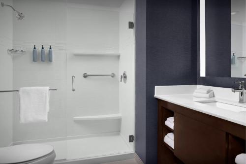 a bathroom with a shower and a toilet and a sink at Residence Inn by Marriott Fort Lauderdale Airport & Cruise Port in Dania Beach