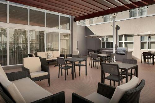 a restaurant with tables and chairs and windows at Residence Inn by Marriott Fort Lauderdale Airport & Cruise Port in Dania Beach