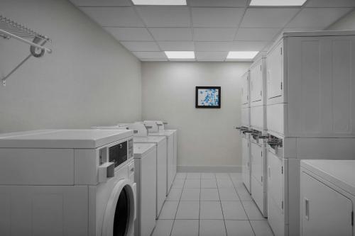 a laundry room with a row of washers and dryers at Residence Inn by Marriott Fort Lauderdale Airport & Cruise Port in Dania Beach