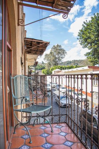 a balcony with a table and chairs on a patio at CORAZÓN DE TEPOZ in Tepoztlán