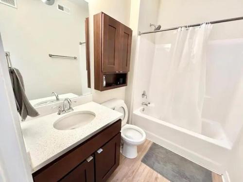 a bathroom with a sink and a toilet and a shower at Urban Oasis Downtown Condo with Skywalk Access 5 in Des Moines