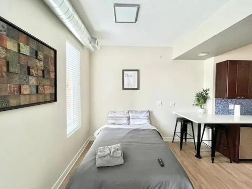 a bedroom with a bed and a table in it at Urban Oasis Downtown Condo with Skywalk Access 5 in Des Moines