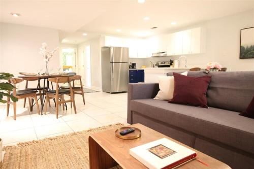 a living room with a gray couch and a kitchen at Lincoln Park Place Capitol Hill with Parking in Washington, D.C.