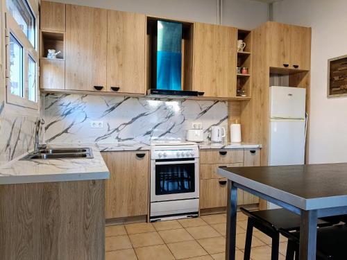 a kitchen with wooden cabinets and a white stove top oven at Holiday House in Porto Heli