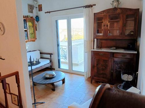 a living room with a table and a sliding glass door at Holiday House in Porto Heli