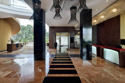 um átrio com colunas pretas e um corredor com um átrio em Accra Marriott Hotel em Accra