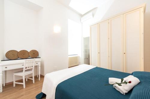 Un dormitorio blanco con una cama azul y un escritorio. en La Corallina, en Santa Margherita Ligure