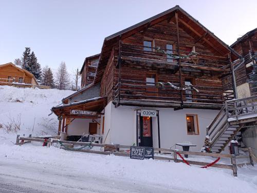 une cabane en rondins dans la neige avec un panneau devant dans l'établissement Õ 2040 Chambre Marmotte, à Saint-Véran