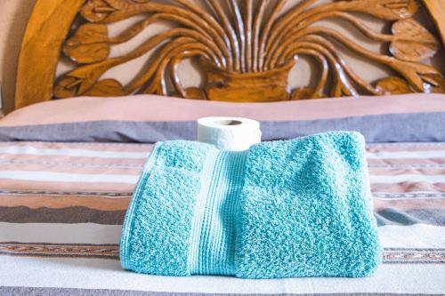 a blue towel and a roll of toilet paper on a bed at CORAZÓN DE TEPOZ in Tepoztlán