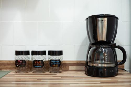 um liquidificador num balcão com três frascos de especiarias em 2 dorm em um prédio charmoso da decada de 1950 em São Paulo