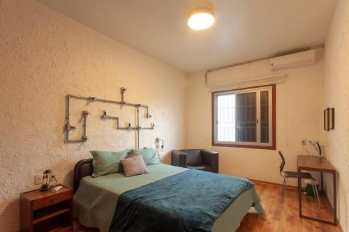 um quarto com uma cama e uma janela em 2 dorm em um prédio charmoso da decada de 1950 em São Paulo