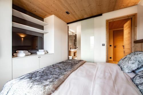 une chambre avec un lit et un plafond en bois dans l'établissement Appartement de charme au pied des pistes de Cordon, à Cordon