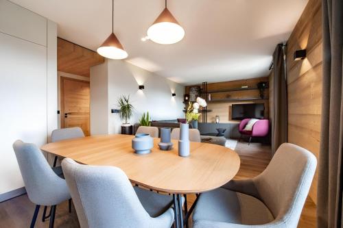 une salle à manger avec une table et des chaises en bois dans l'établissement Appartement de charme au pied des pistes de Cordon, à Cordon