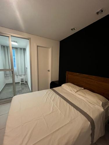 ベロオリゾンテにあるRaja Flatの黒い壁のベッドルーム1室(白い大型ベッド1台付)